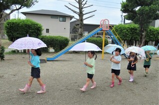 5歳児が傘を差して歩いていることろ