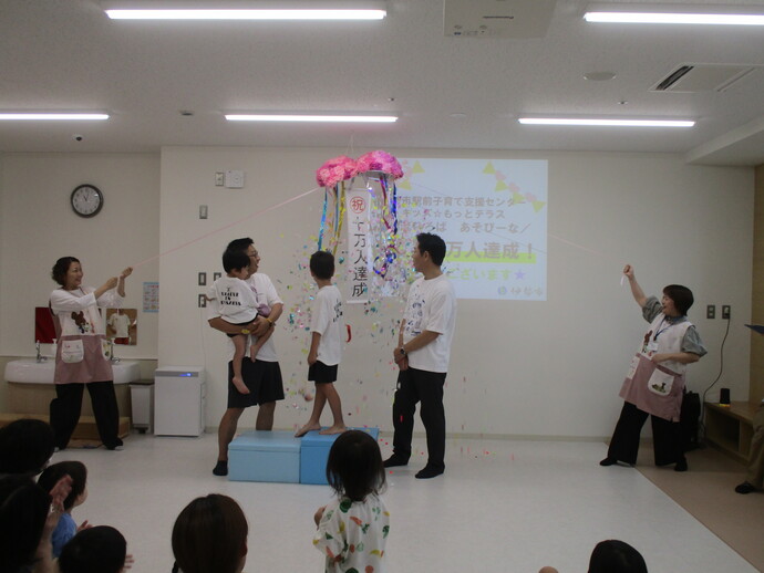 10万人を記念してくす玉を割っている写真